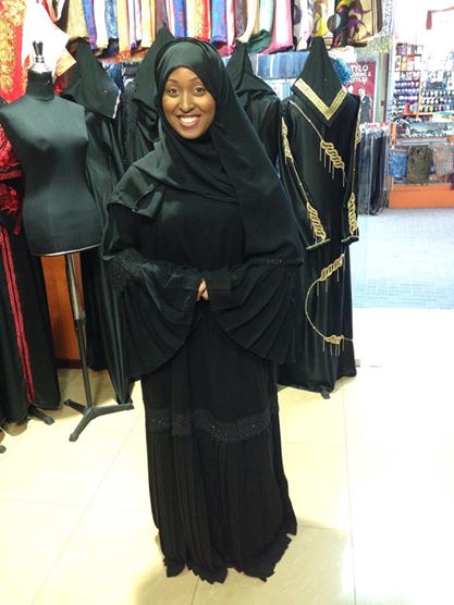 Trying on an abaya for the first time in Bahrain before heading to Saudi Arabia. The hijab is worn around the head, the abaya is worn over the body.